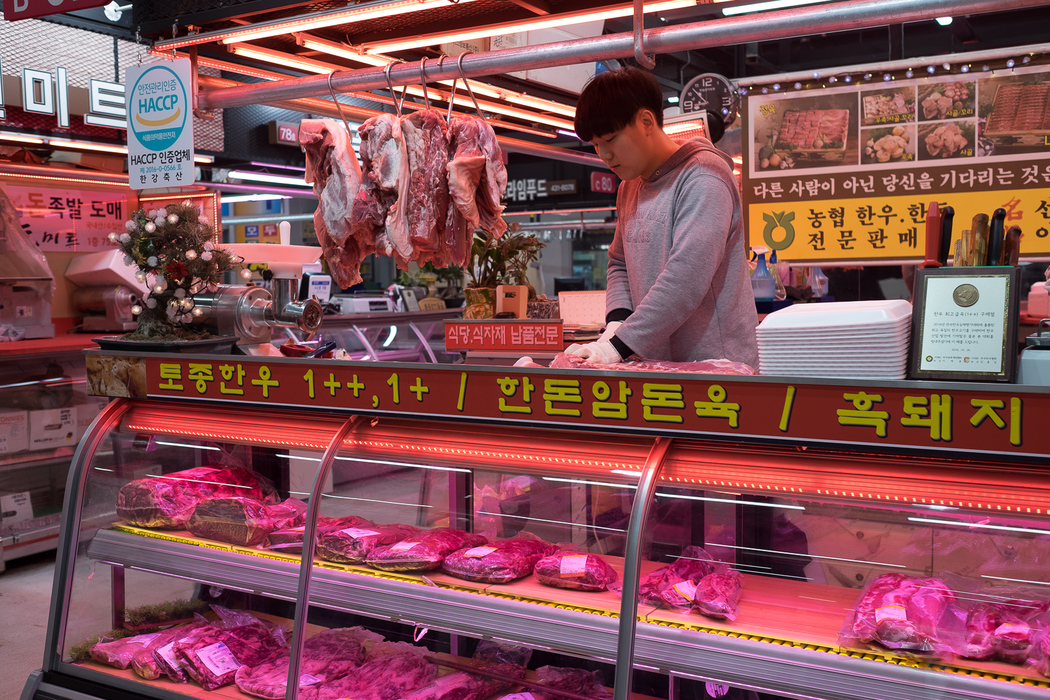 A butcher chops pork in the meat section of Garak Market, Seoul.