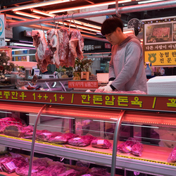 A butcher chops pork in the meat section of Garak Market, Seoul.