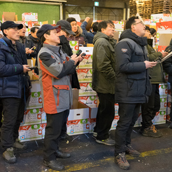 Buyers enter their bids on hand-held electronic devices at a fruit auction inside Garak Market, Seoul.