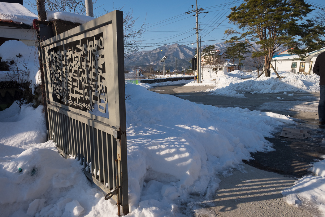 The gates of Kyung-ah's house, featuring Korean calligraphy.