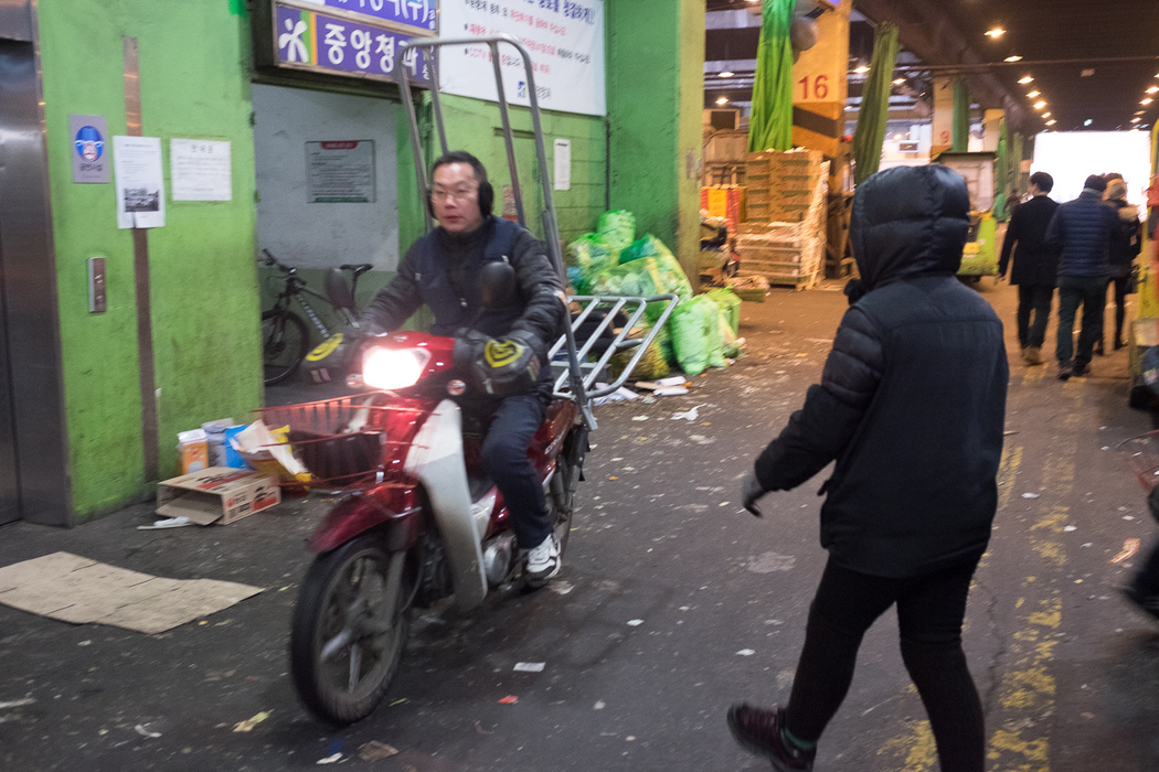 A man rides a delivery scooter inside the Garak market.