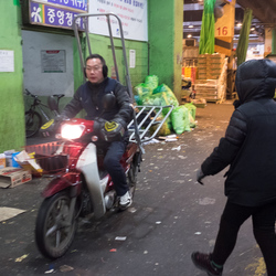 A man rides a delivery scooter inside the Garak market.