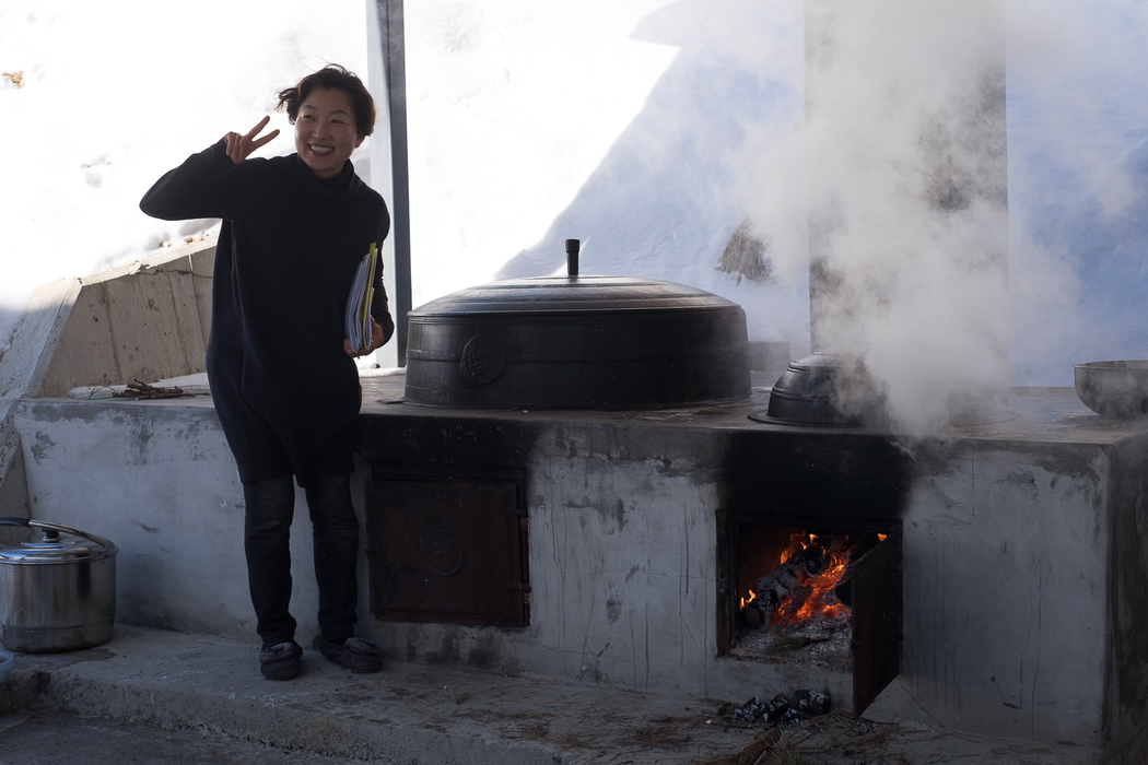 Kim Kyung-hee posing for a photo next to the outdoor oven.